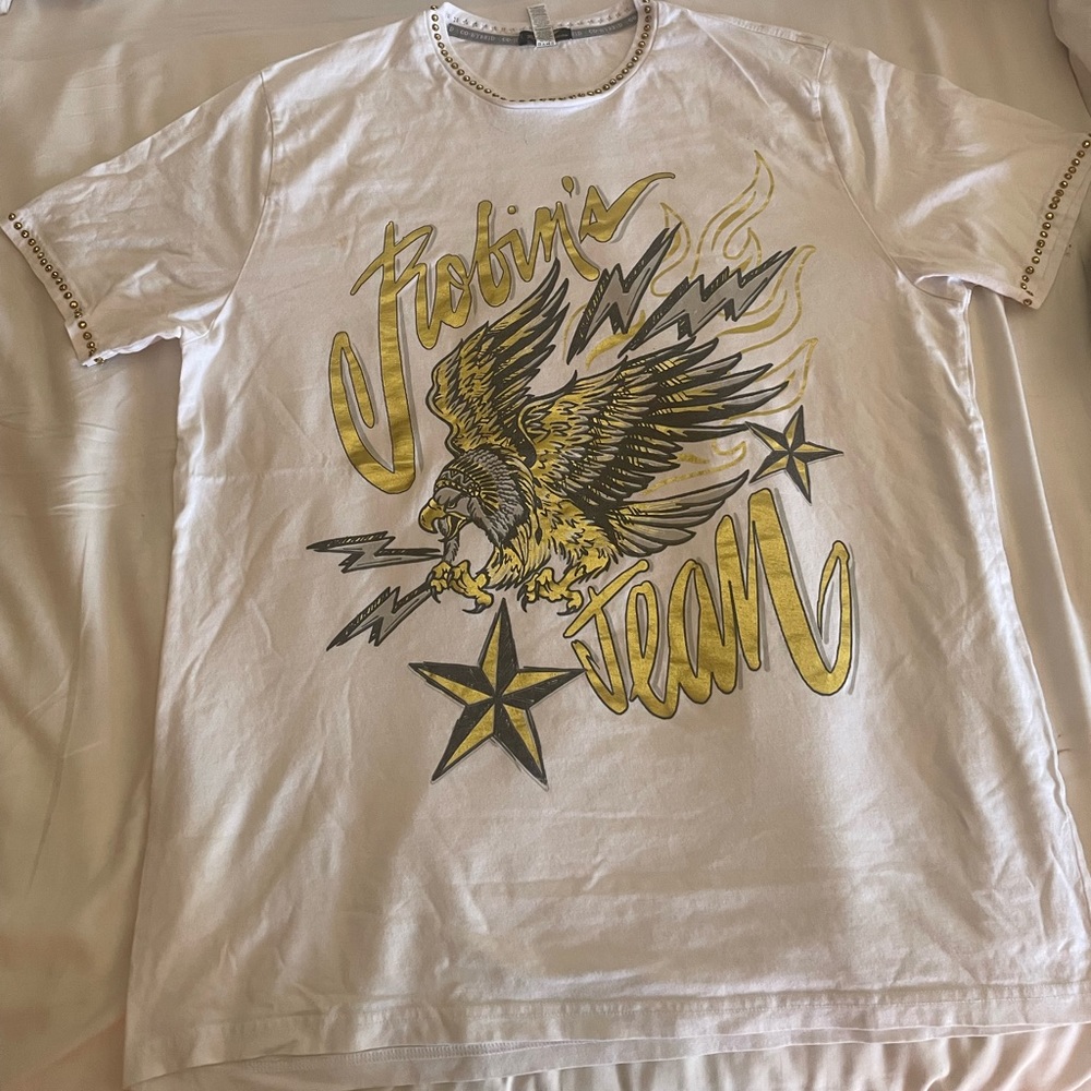 White shirt with gold studs along the brim of the collar and sleeves